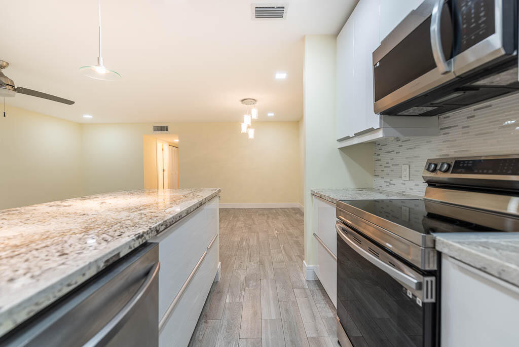 14250 Nesting Way, Unit B Delray Beach, FL 33484 - Photo 17 of 45 a kitchen with granite countertop a sink and cabinets