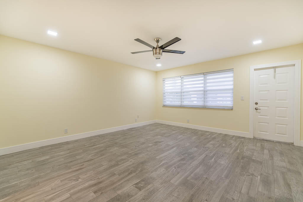 14250 Nesting Way, Unit B Delray Beach, FL 33484 - Photo 21 of 45 an empty room with wooden floor ceiling fan and windows