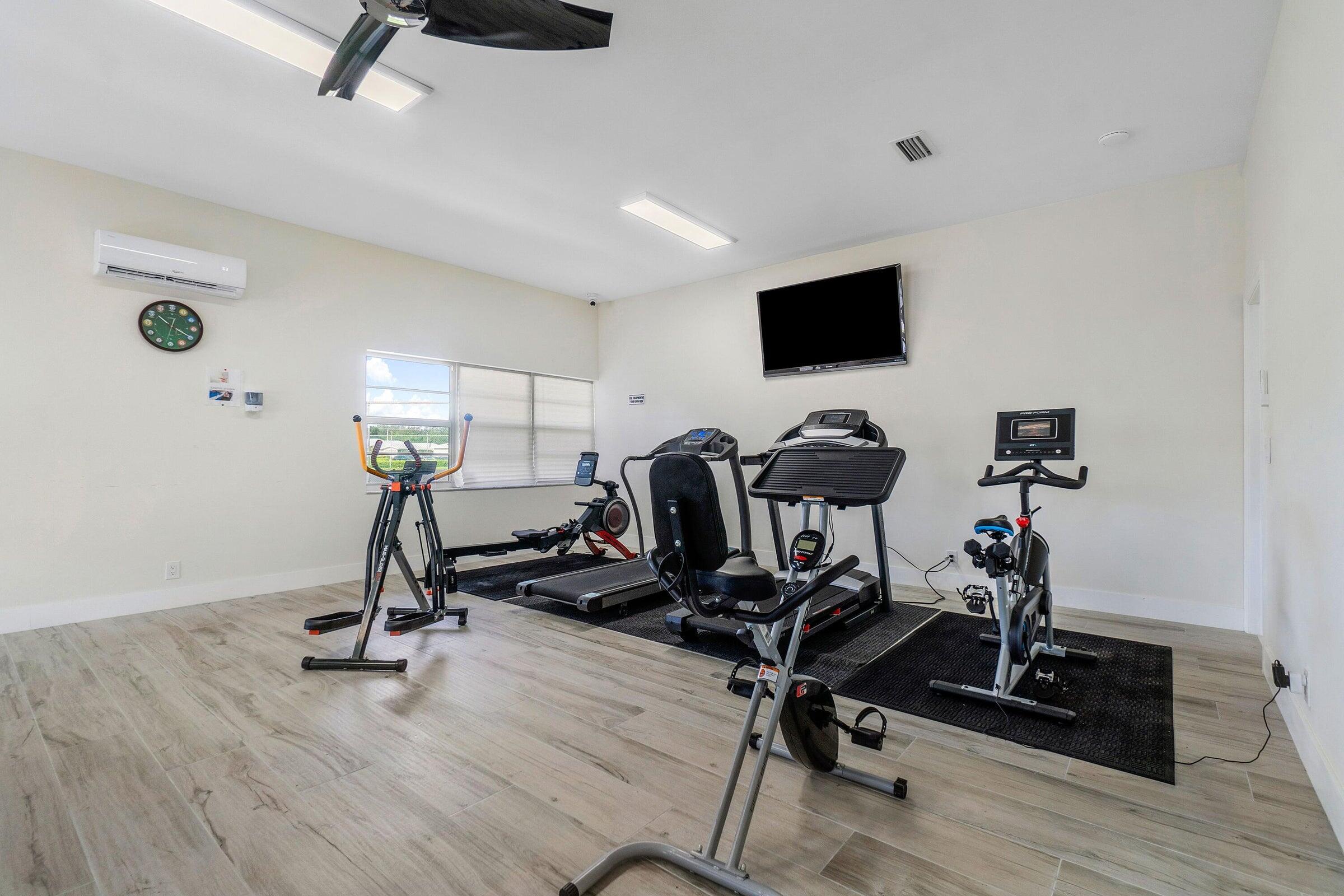 14250 Nesting Way, Unit B Delray Beach, FL 33484 - Photo 43 of 45 a view of a workspace with furniture and gym cycle