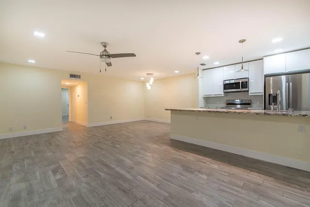 a view of a kitchen with a sink and a refrigerator