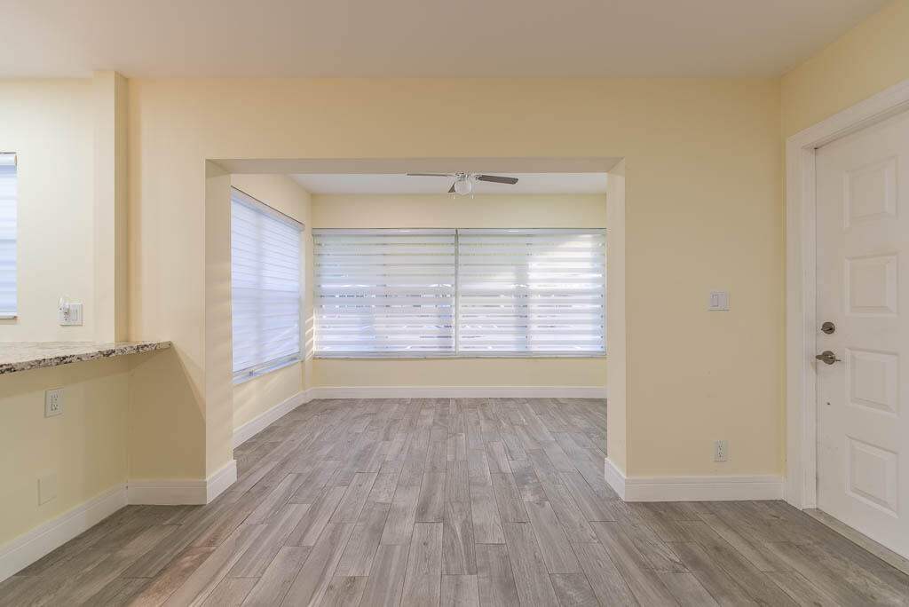 14250 Nesting Way, Unit B Delray Beach, FL 33484 - Photo 9 of 45 an empty room with wooden floor and windows