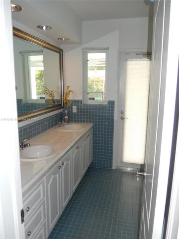 a bathroom with a double vanity sink and a mirror