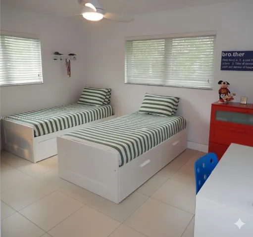 a bedroom with two beds and a window