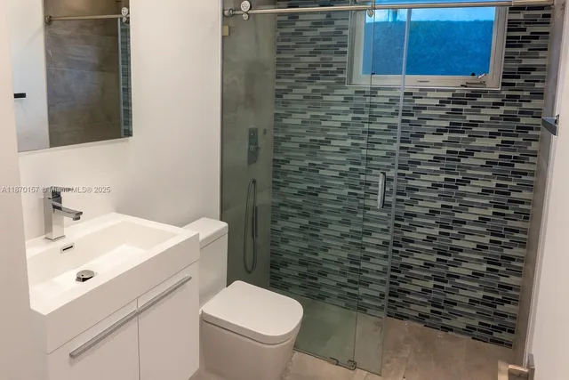 a bathroom with a sink a toilet and a mirror