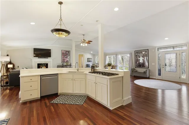 a large kitchen with a lot of counter space and wooden floor