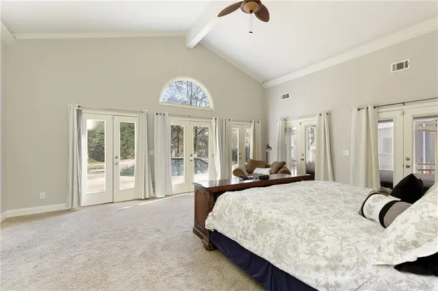 a large bedroom with bed and large window