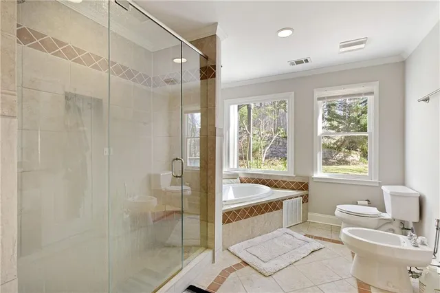 a bathroom with a tub sink toilet and next to a window