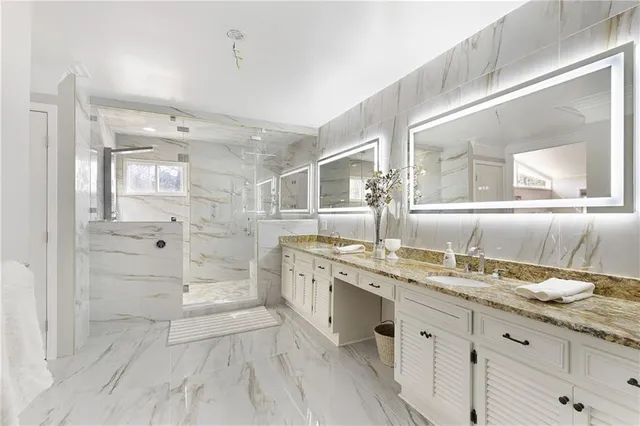 a spacious bathroom with a granite countertop sink mirror and a