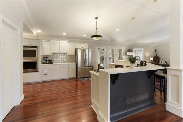 a kitchen with kitchen island a sink stainless steel appliances and cabinets