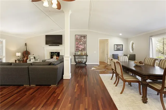 a living room with furniture a flat screen tv and kitchen view