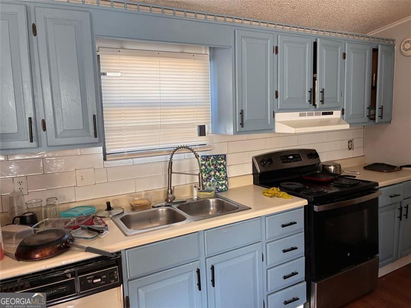 5165 Sycamore Trail, Unit 285 Buford, GA 30518 - Photo 2 of 7 a kitchen with a sink stove top oven and cabinets