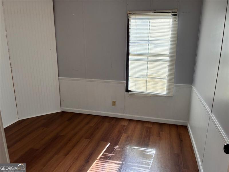 5165 Sycamore Trail, Unit 285 Buford, GA 30518 - Photo 5 of 7 an empty room with wooden floor and windows