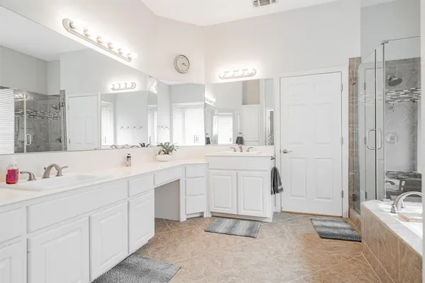 a spacious bathroom with a double vanity sink mirror and double