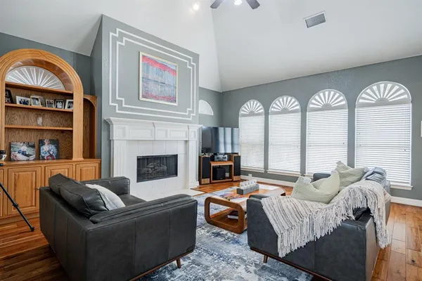 a living room with furniture a fireplace and a floor to ceiling window