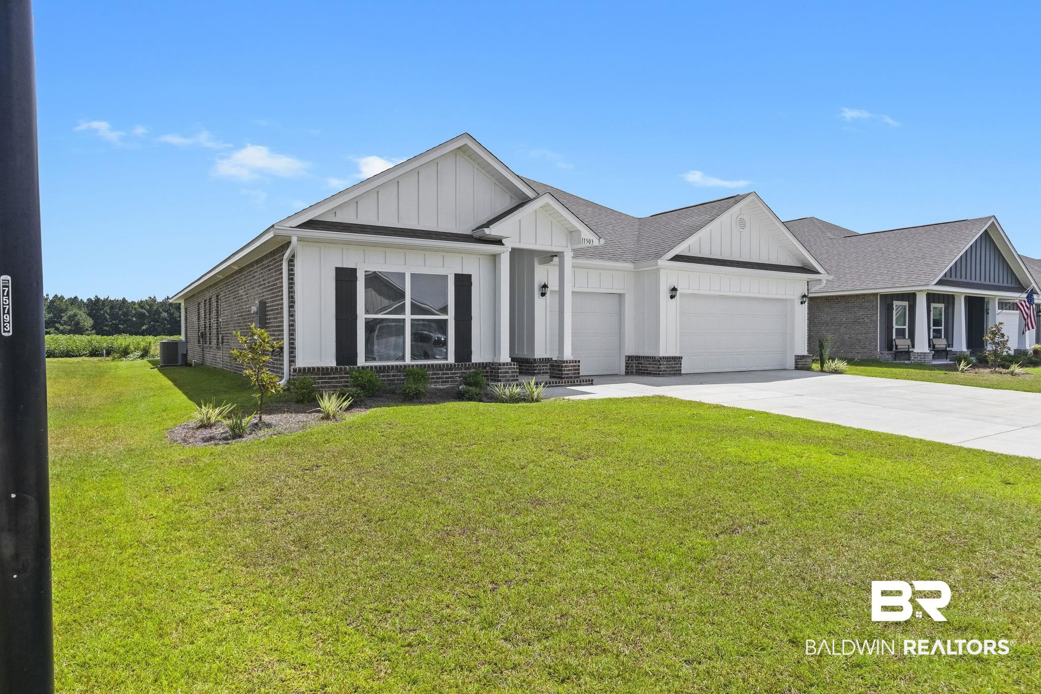 11303 Genuine Risk Circle Daphne, AL 36526 - Photo 4 of 100 View of front facade with central AC unit, a garage, and a front lawn