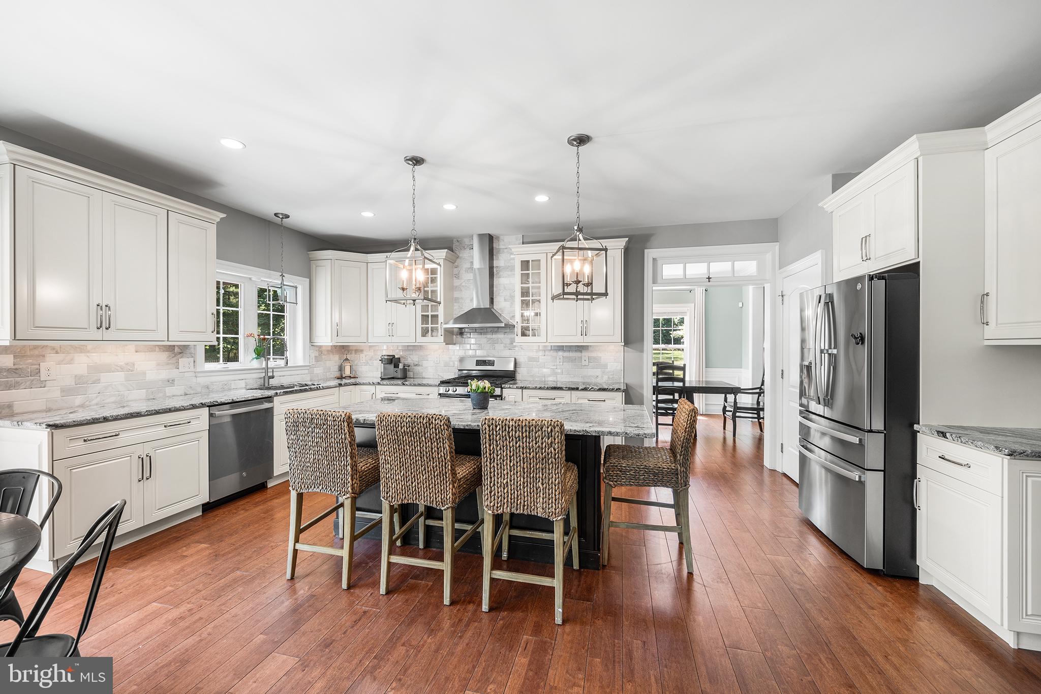 515 Old Eagle School Road Wayne, PA 19087 - Photo 11 of 40 a kitchen with a dining table chairs wooden floor cabinets and appliances