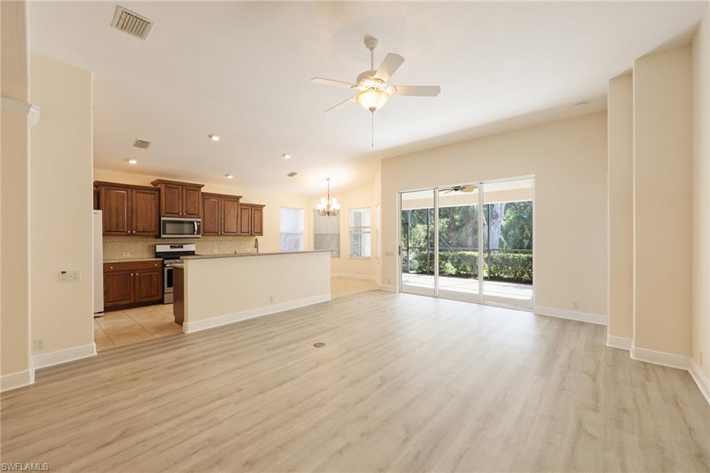 20411 Rookery Drive Estero, FL 33928 - Photo 5 of 29 Kitchen featuring tasteful backsplash, appliances with stainless steel finishes, a kitchen island, light hardwood / wood-style floors, and pendant lighting