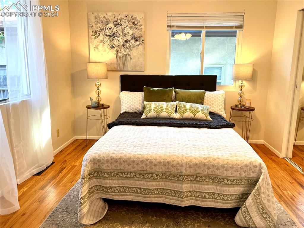 929 Sunset Road Colorado Springs, CO 80909 - Photo 25 of 45 a bedroom with a bed and wooden floor