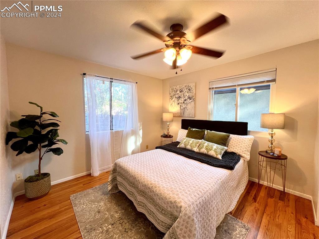 929 Sunset Road Colorado Springs, CO 80909 - Photo 28 of 45 a bedroom with a bed and a chandelier