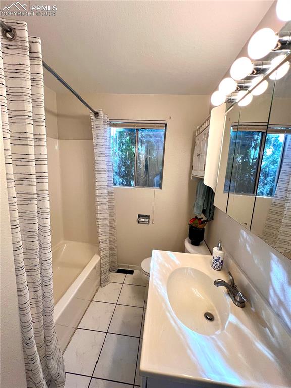 929 Sunset Road Colorado Springs, CO 80909 - Photo 35 of 45 a bathroom with a tub a sink and a large mirror