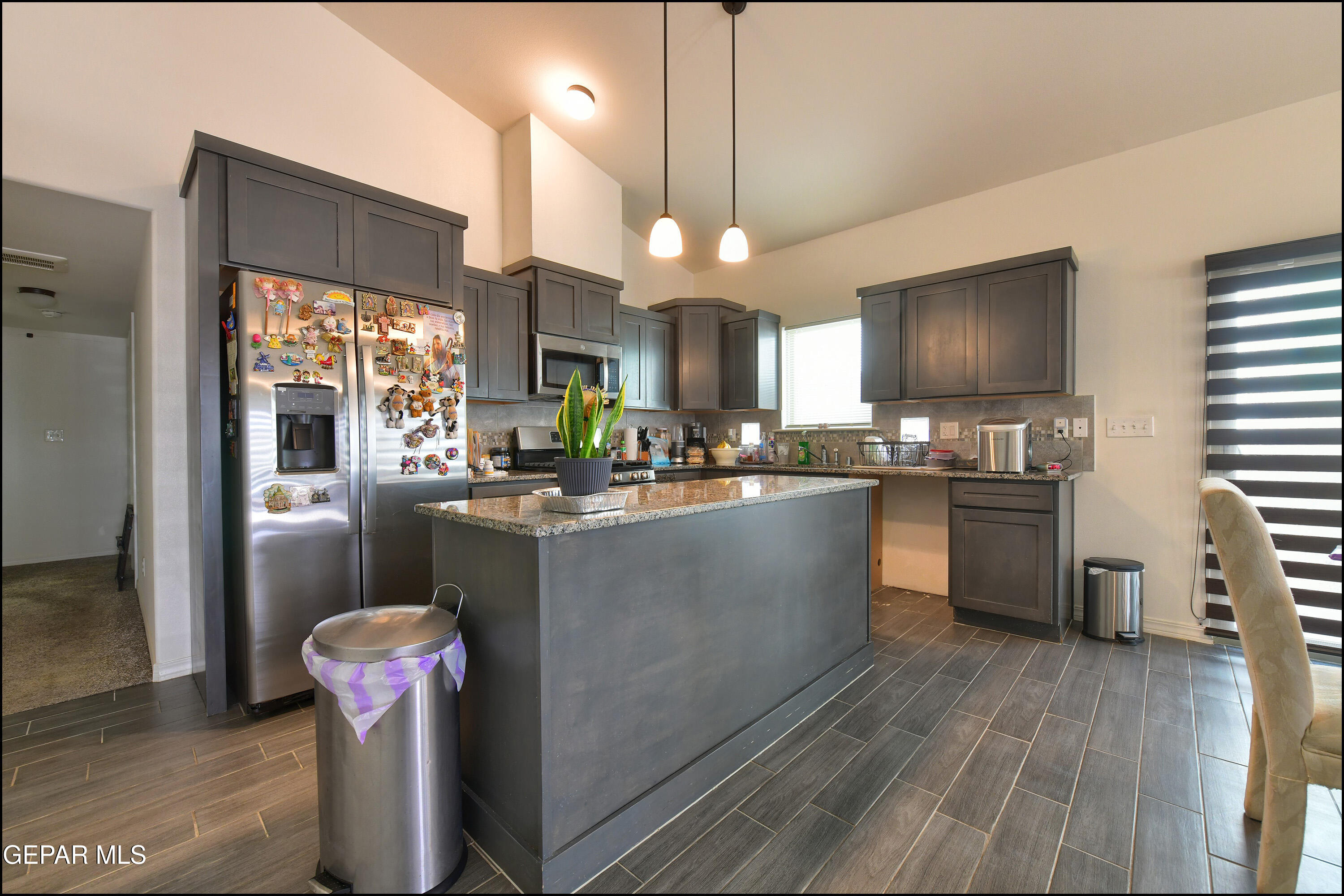 235 Herts Way El Paso, TX 79928 - Photo 11 of 35 a kitchen with stainless steel appliances granite countertop a refrigerator a sink dishwasher a stove and a dining table with wooden floor