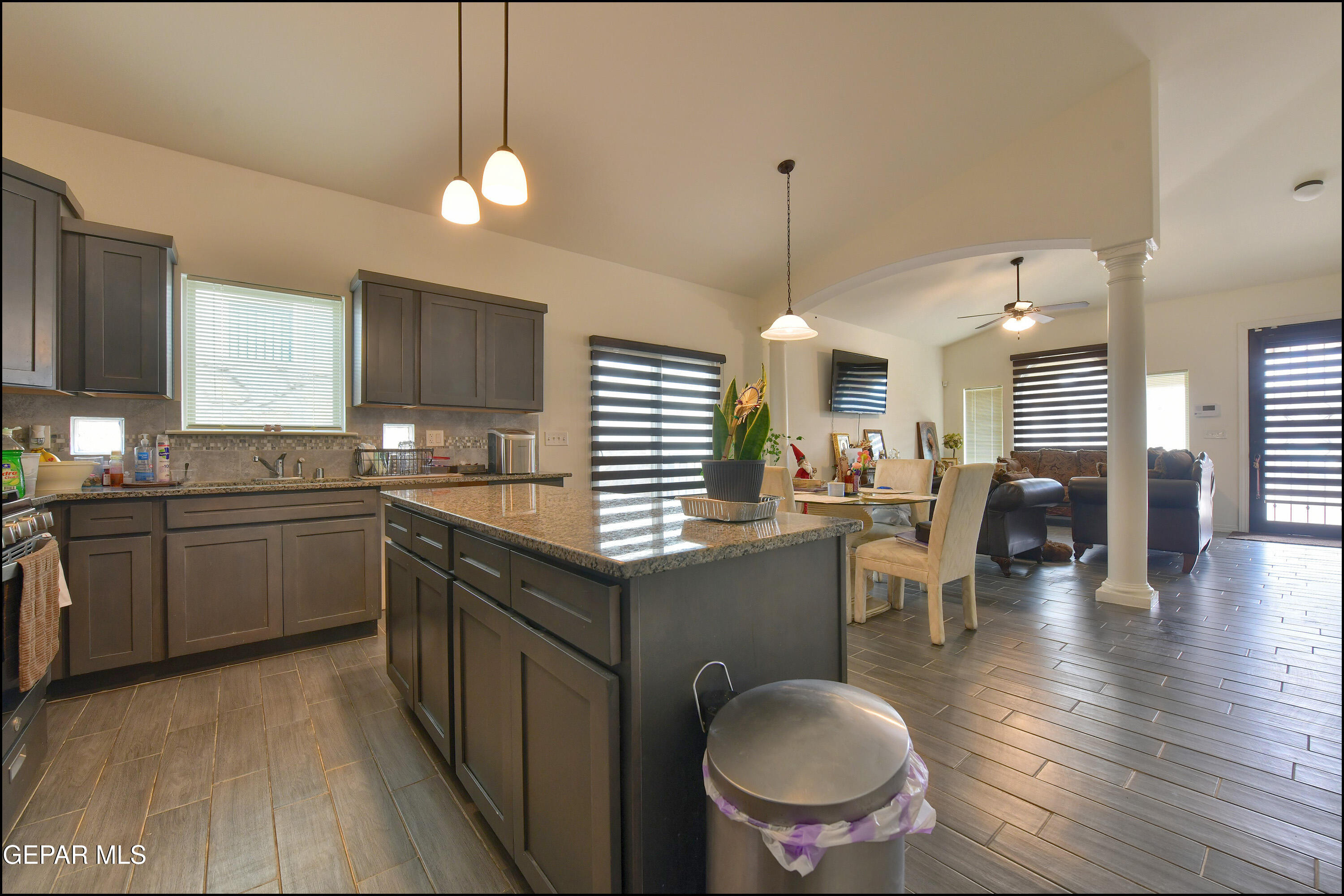 235 Herts Way El Paso, TX 79928 - Photo 12 of 35 a kitchen with a refrigerator a sink dishwasher a dining table and chairs with wooden floor