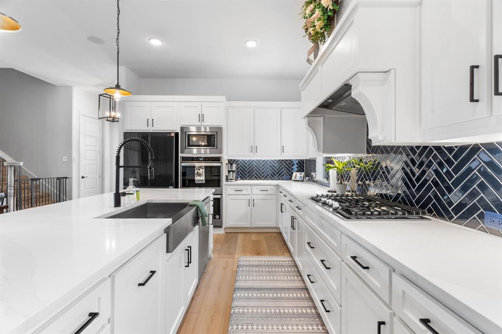 1898 Tumblegrass Road Frisco, TX 75033 - Photo 11 of 40 a kitchen with stainless steel appliances a sink stove and cabinets