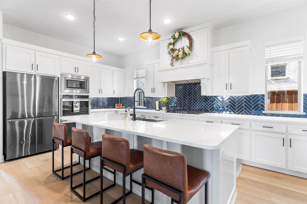 1898 Tumblegrass Road Frisco, TX 75033 - Photo 13 of 40 a kitchen with kitchen island granite countertop a sink a center island and cabinets