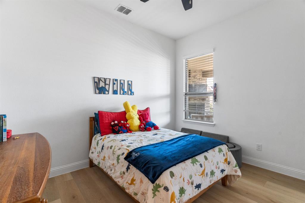 1898 Tumblegrass Road Frisco, TX 75033 - Photo 23 of 40 a bedroom with a bed and a chair