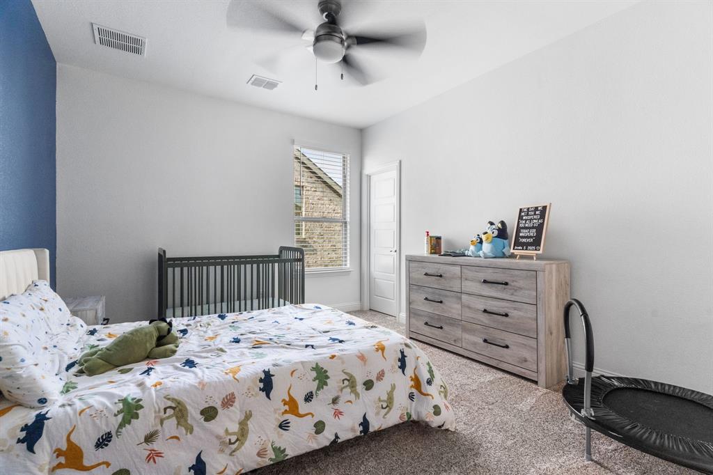 1898 Tumblegrass Road Frisco, TX 75033 - Photo 28 of 40 a bedroom with a bed a dresser and a window
