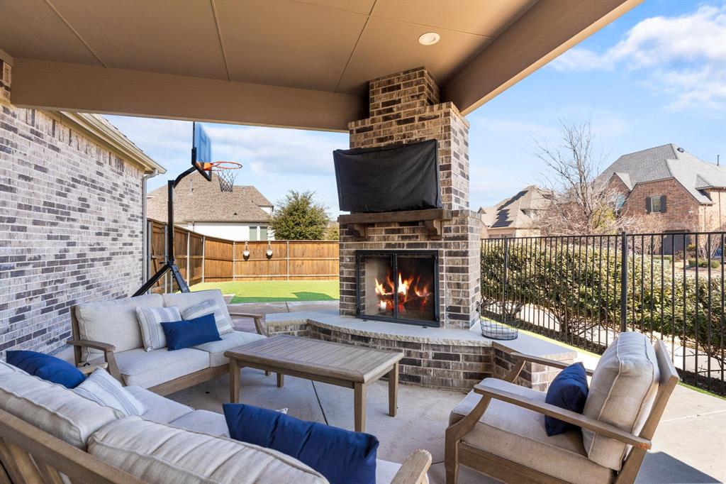 1898 Tumblegrass Road Frisco, TX 75033 - Photo 4 of 40 a living room with furniture a flat screen tv and a fireplace