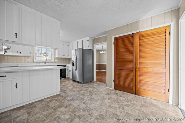 a kitchen with refrigerator cabinets and a window