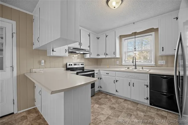 a kitchen with white cabinets and a sink