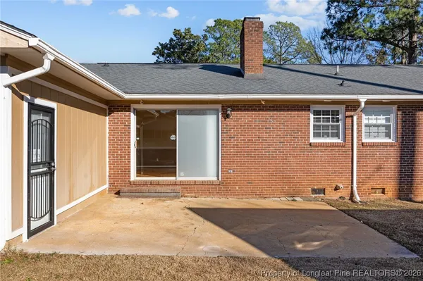a view of a house with backyard and a tree