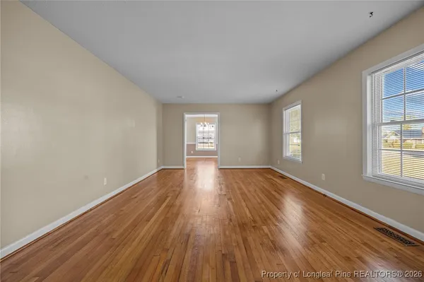 a view of empty room with window and wooden floor