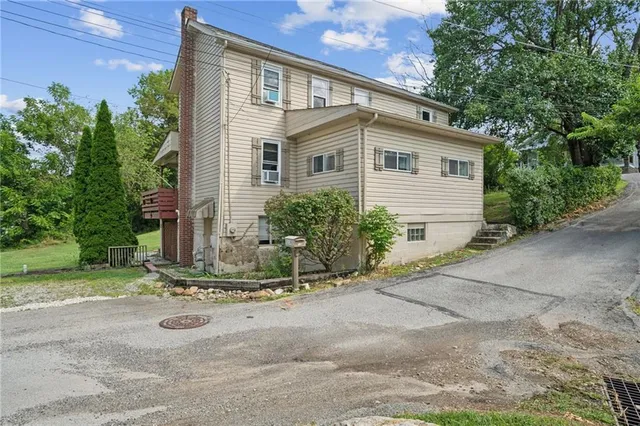a view of a house with backyard and trees