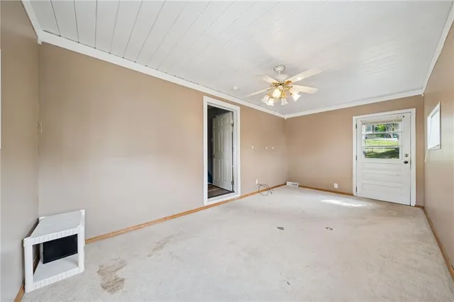 an empty room with a ceiling fan and a window