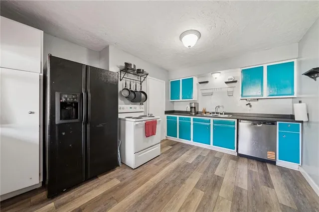 a kitchen with stainless steel appliances granite countertop a refrigerator and a sink