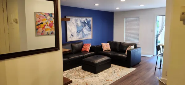 a living room with furniture and wooden floor
