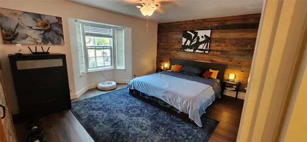 a bedroom with a bed and a painting on the wall