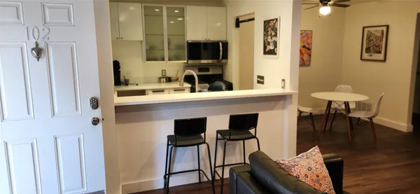 a kitchen with stainless steel appliances kitchen island granite countertop a table and chairs in it