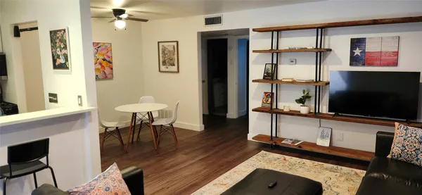 a living room with furniture a flat screen tv and a dining table