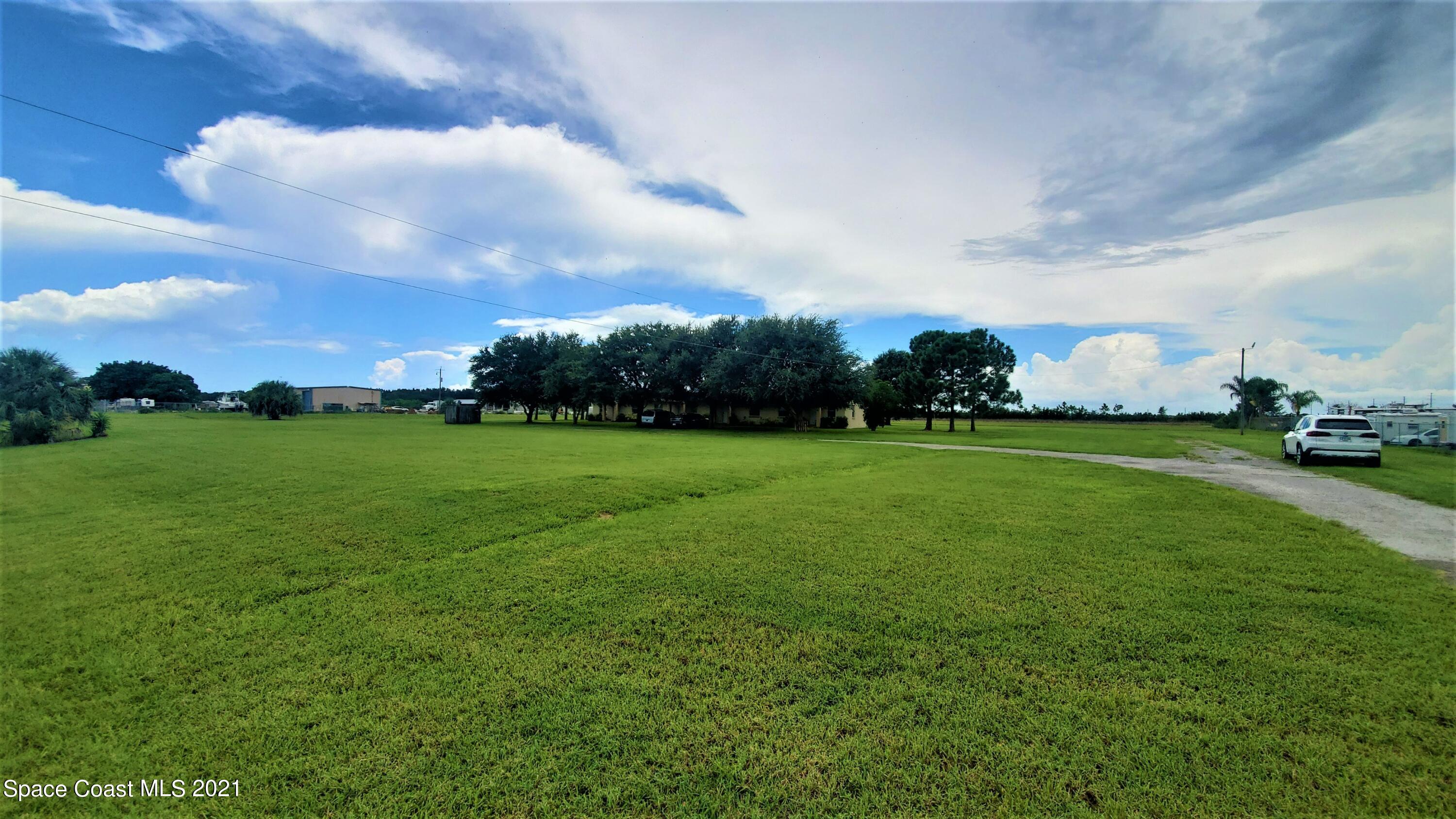 4521 Micco Road Micco, FL 32976 - Photo 6 of 12 a view of a field of grass and trees
