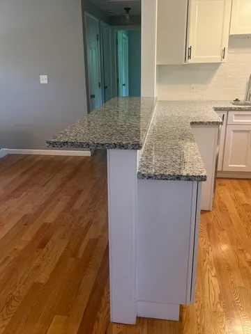a kitchen with granite countertop sink and cabinets