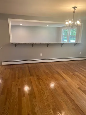 a view of a room with wooden floor and window