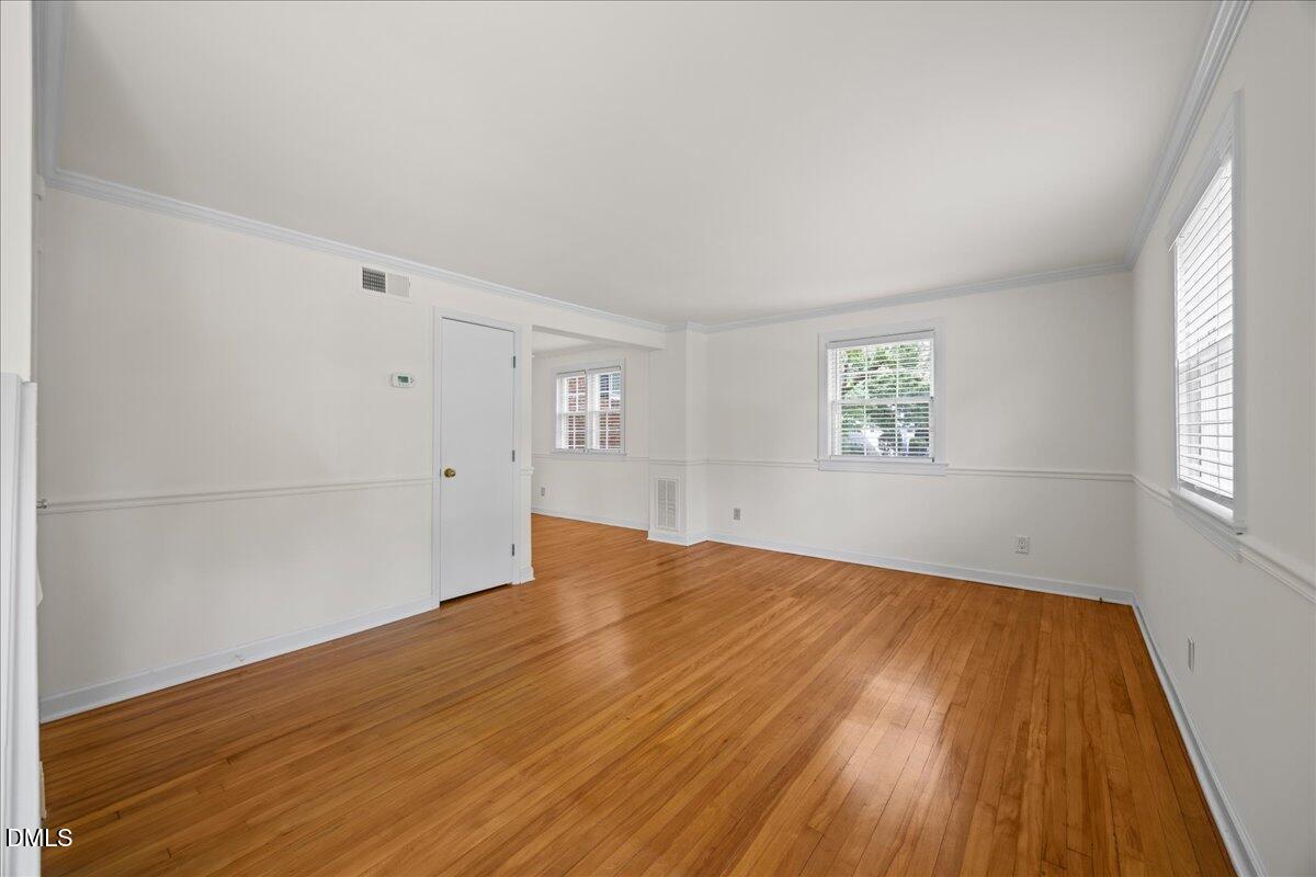 1627 Sutton Drive Raleigh, NC 27605 - Photo 6 of 33 wooden floor in an empty room with a window