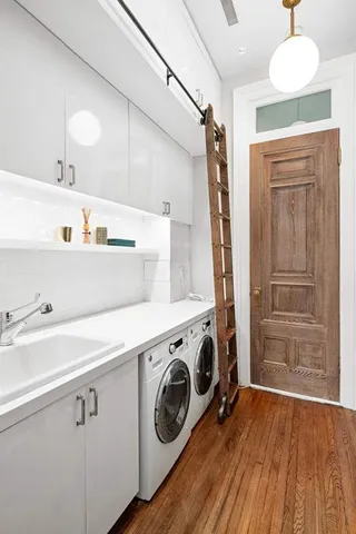 a utility room with wooden floor washer and dryer