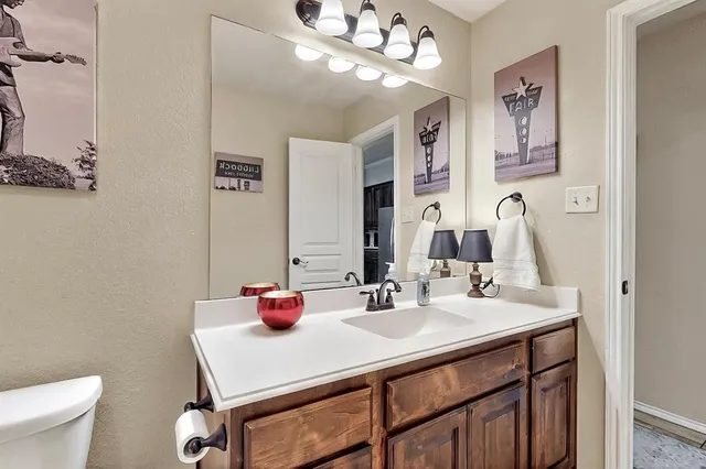 a bathroom with a sink vanity mirror and toilet