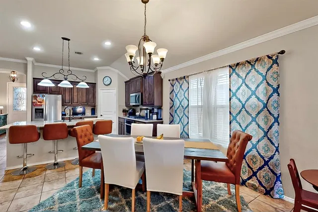 a view of a dining room with furniture a chandelier and wooden floor