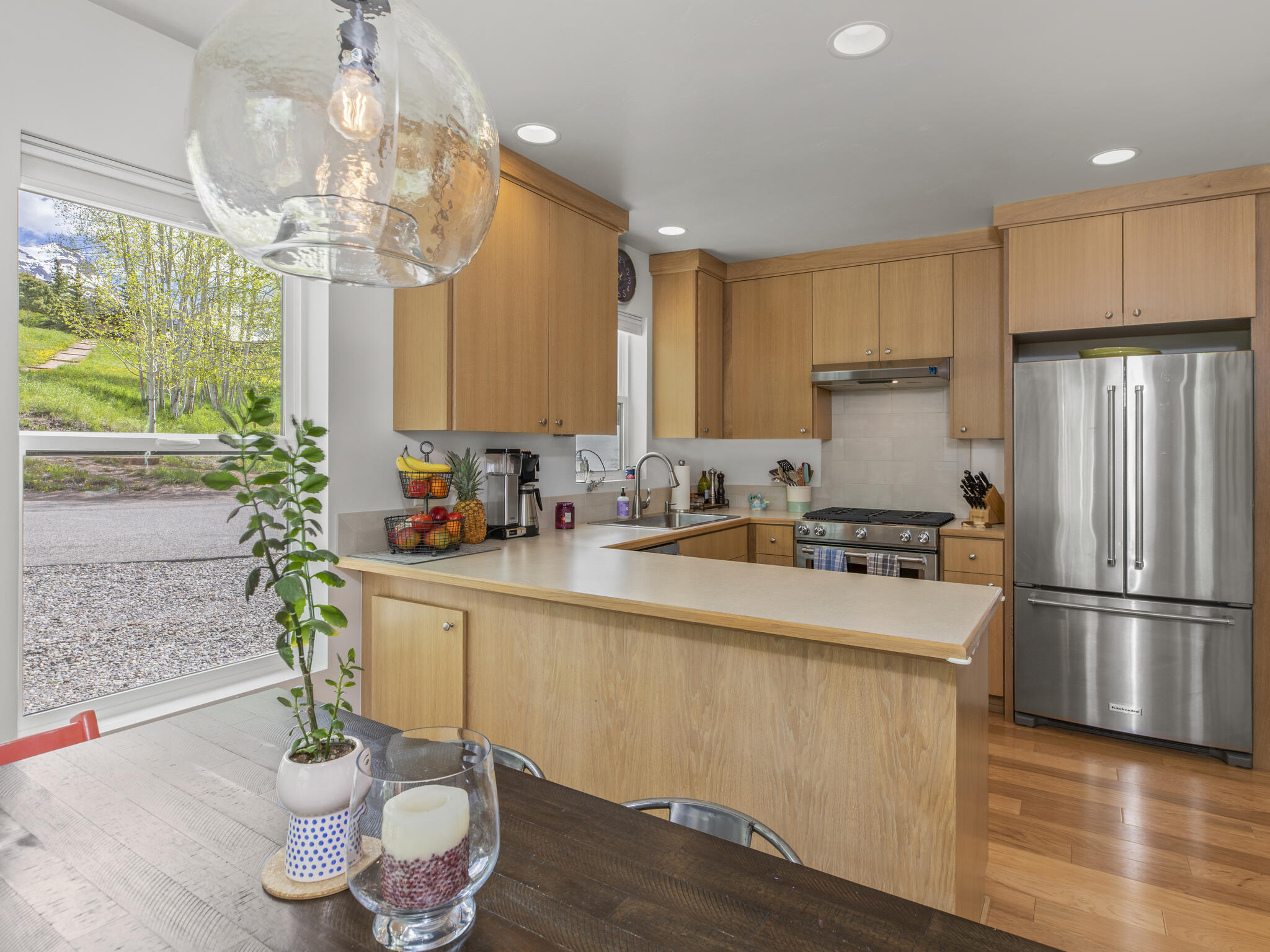 165 Alexander Overlook Telluride, CO 81435 - Photo 7 of 27 a kitchen with stainless steel appliances granite countertop a refrigerator a sink a stove a dining table and chairs